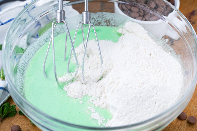 Adding dry ingredients to mint chocolate chick cake wet ingredients.