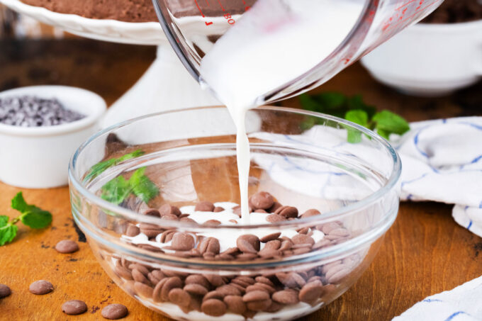 Pouring hot whipping cream over chocolate chips.