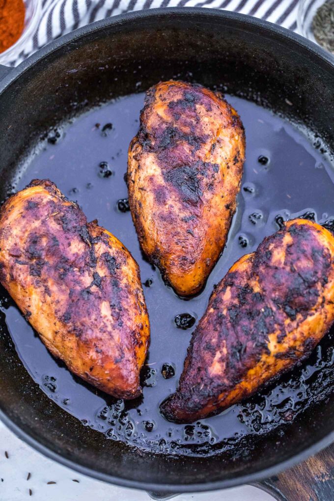 Blackened chicken breasts in a cast iron skillet