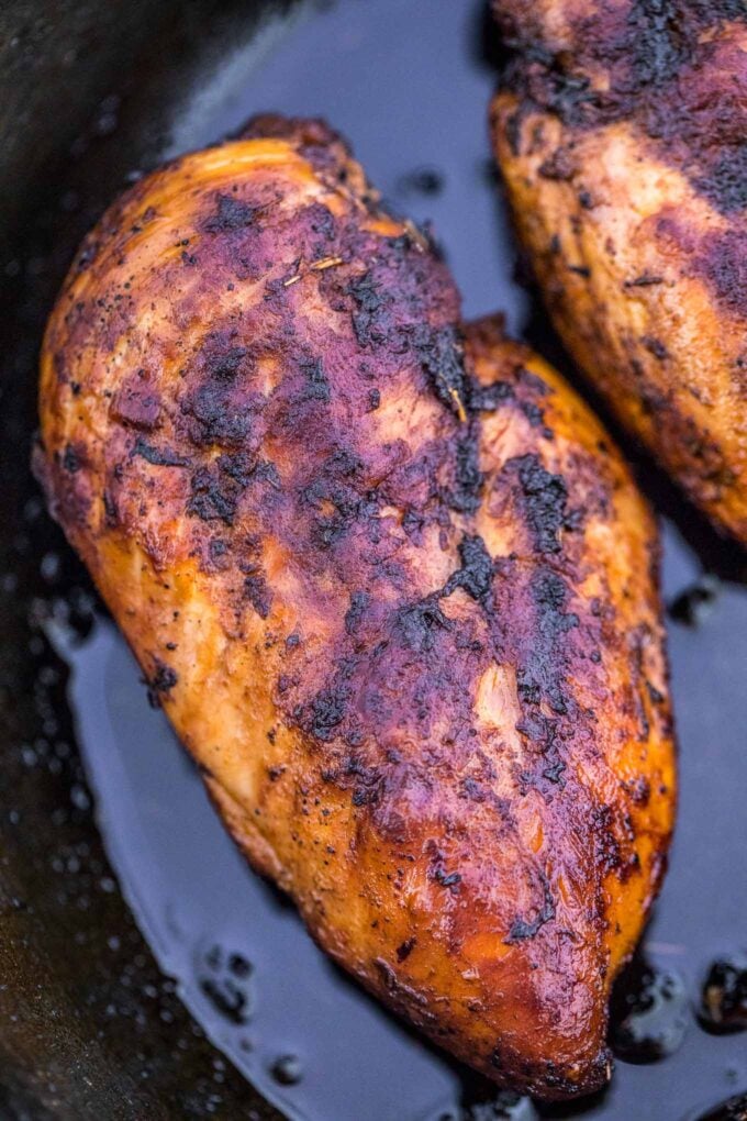 Blackened chicken breasts in a cast iron skillet.