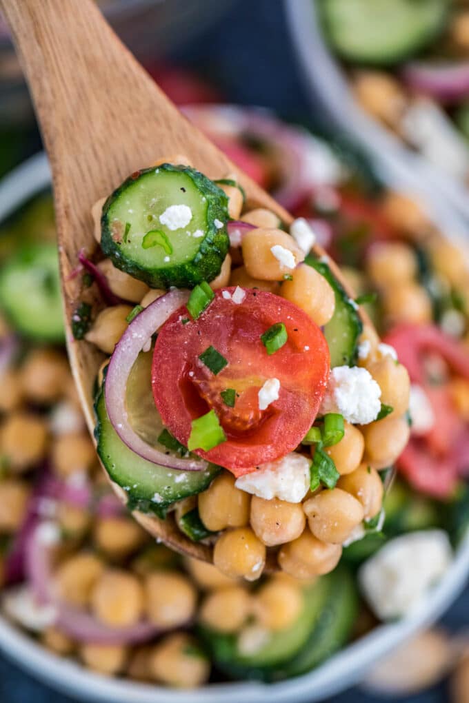 A spoonful of chickpeas, cucumber, feta cheese, and onion. 