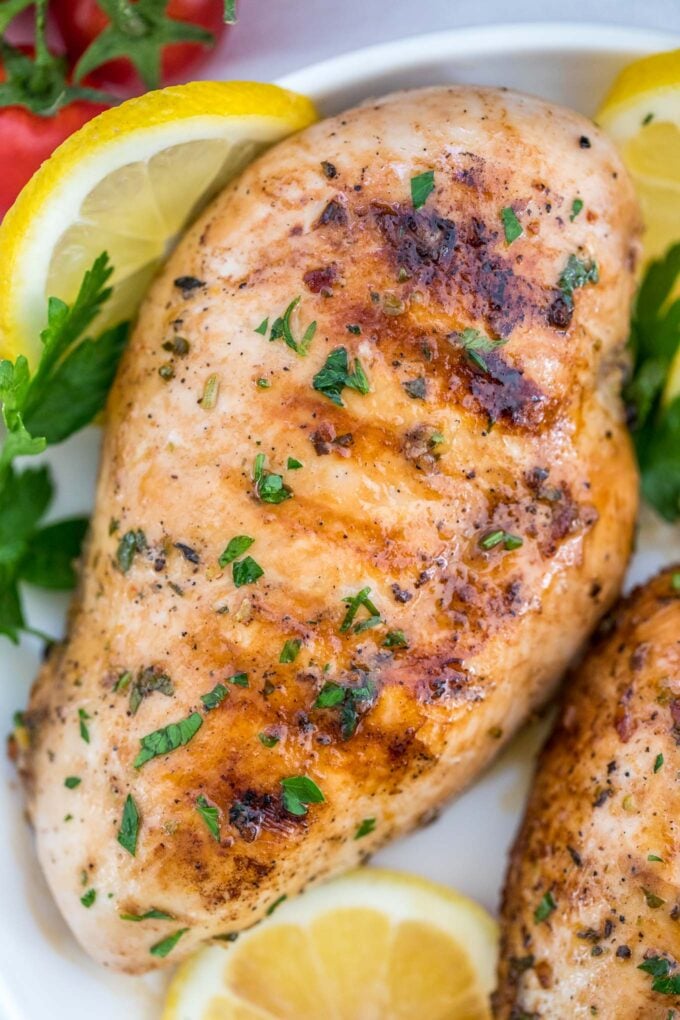 Grilled chicken breasts garnished with chopped parsley