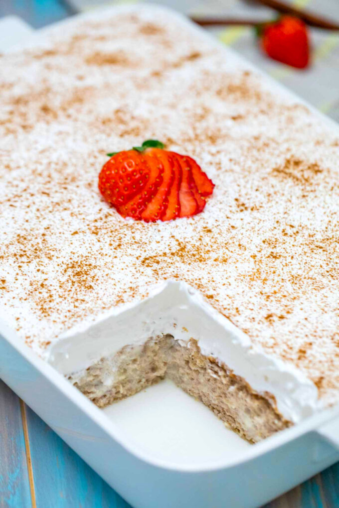 tres leches cake in a baking dish topped with whipped cream.