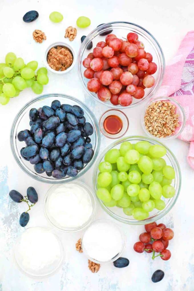 overhead shot of seedless grapes cream cheese whipped cream sugar and vanilla on a table