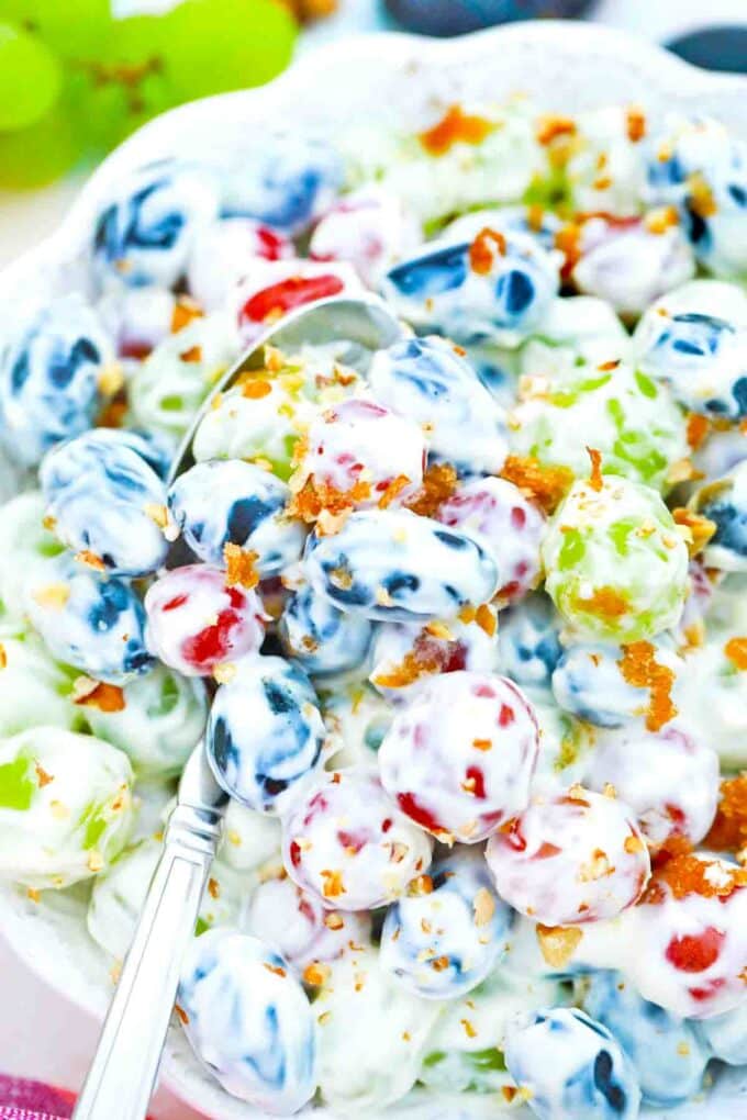 overhead shot of a bowl of grape salad with a spoon in it