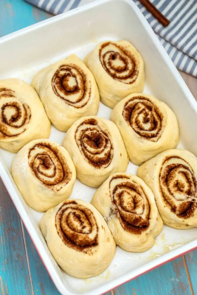 Photo of raw cinnamon rolls in a baking dish.