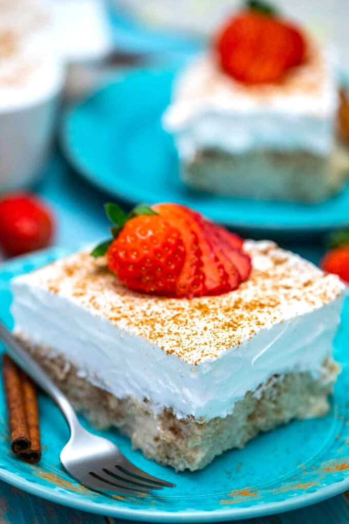 a slice mexican tres leches cake topped with fresh strawberries