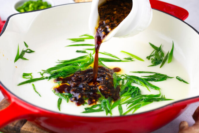 Adding sauce to sauteed geen onions.