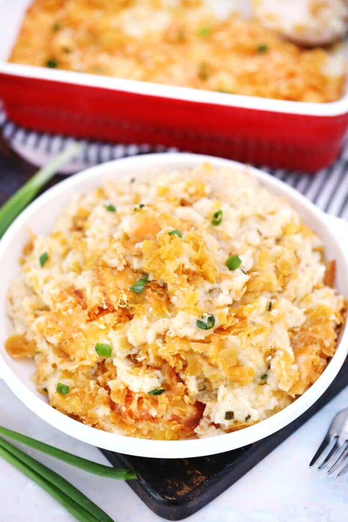 Cheesy potatoes on a white plate image.