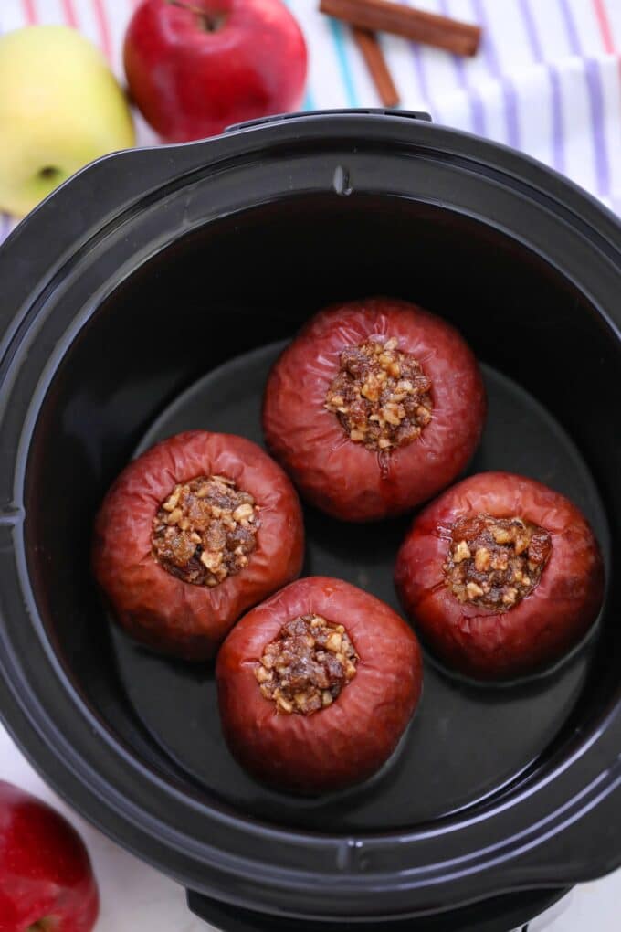 Stuffed apples with chopped walnuts, brown sugar, raisin and butter place in the crockpot