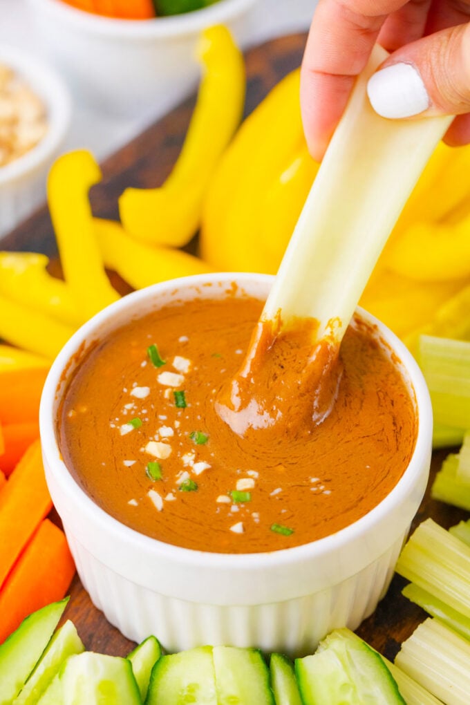 Dipping veggies in creamy peanut sauce.