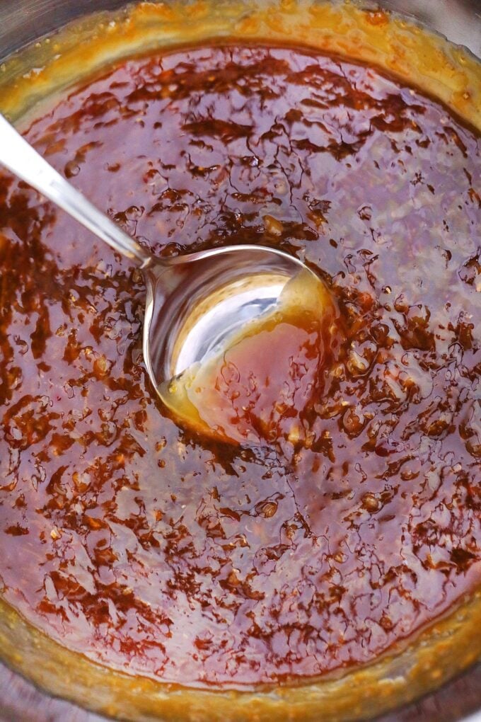 stirring homemade orange sauce in a pan. 