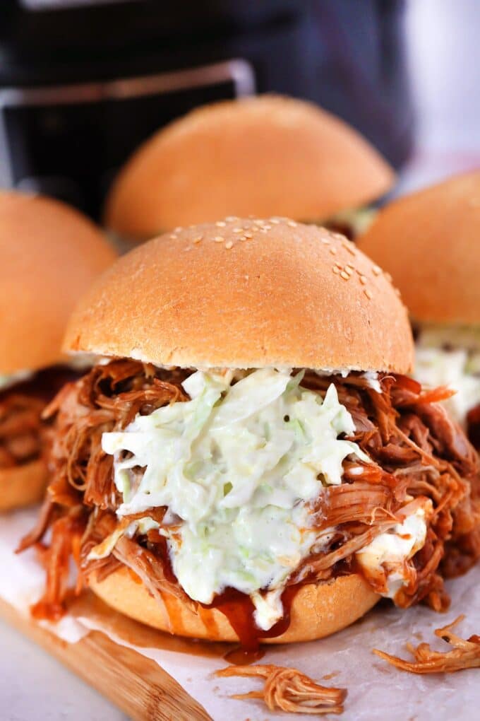 Pulled pork sandwich with coleslaw on a wooden board