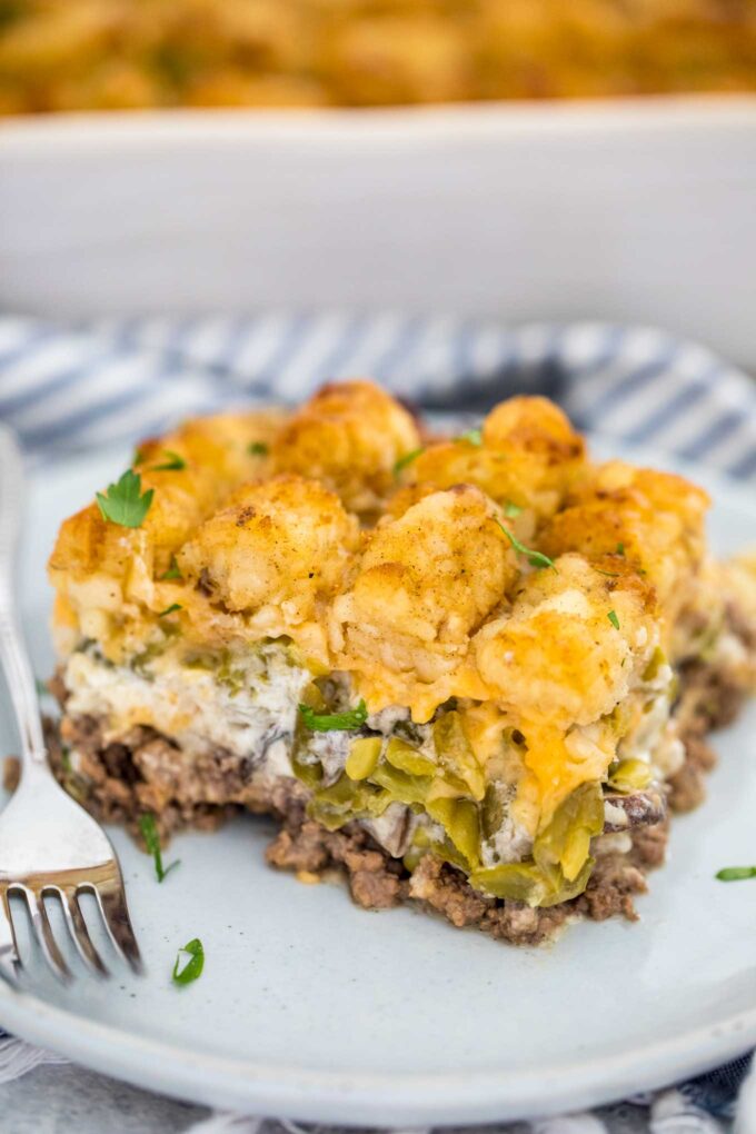 Slice of homemade tater tot casserole on a white plate. 