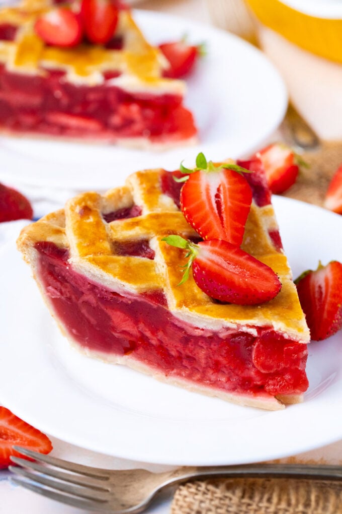 A slice of strawberry pie topped with fresh strawberries.