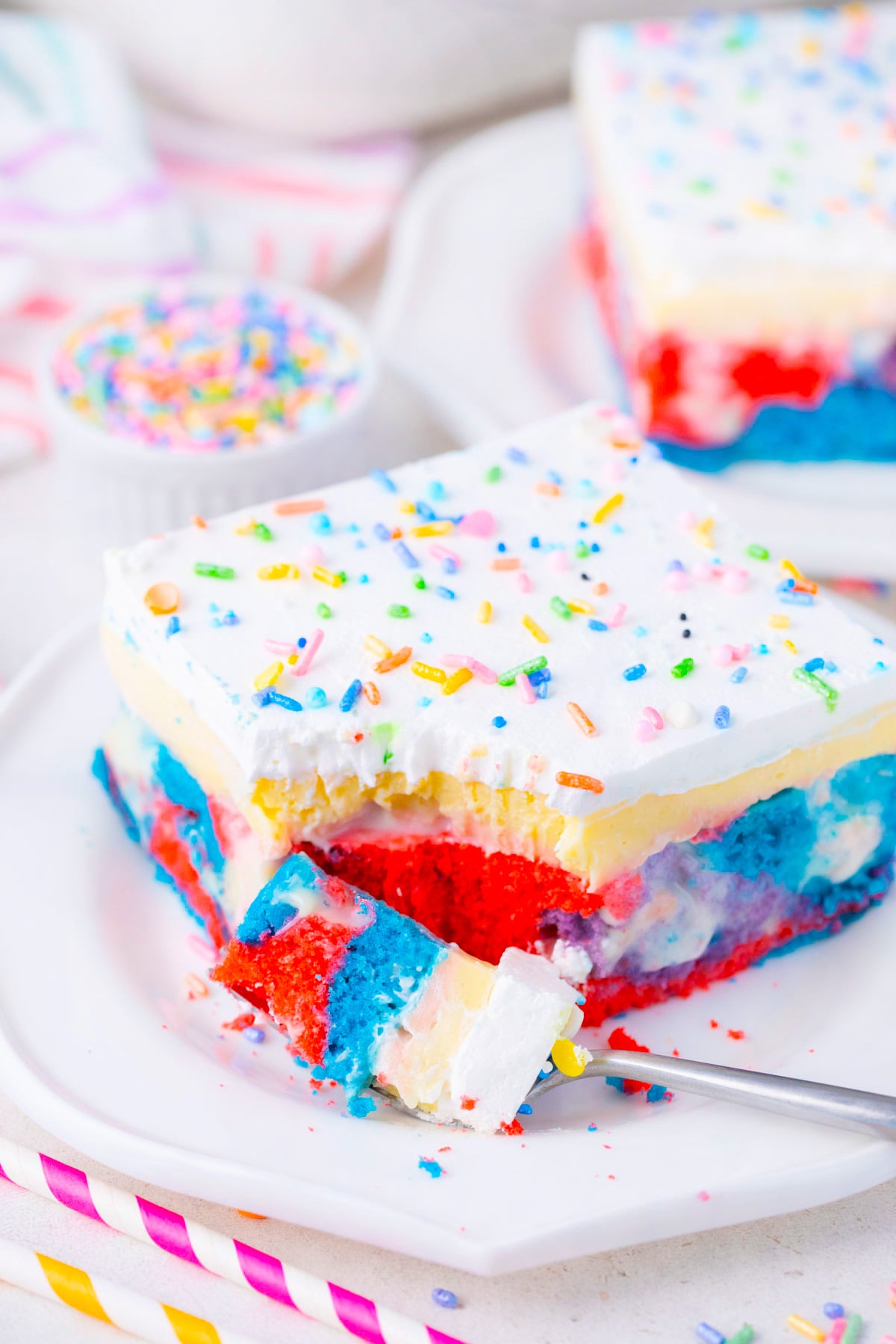 A slice of pink, light blue, and purple unicorn poke cake.