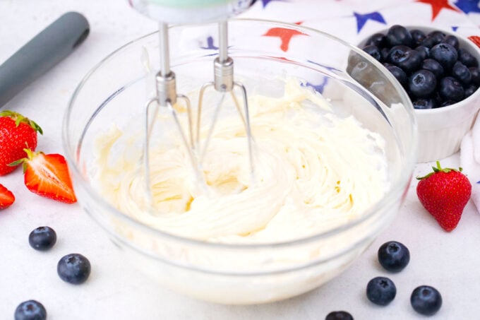 Whipping cream cheese and powdered sugar in a bowl.