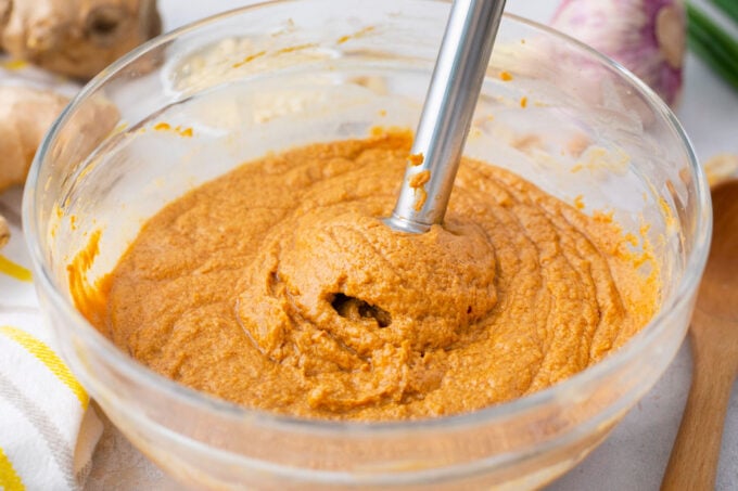Blending creamy peanut sauce ingredients in a bowl.