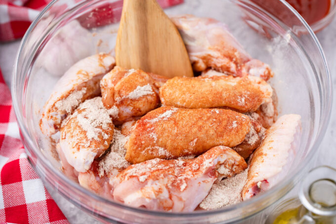 Mixing chicken wings with seasoning.