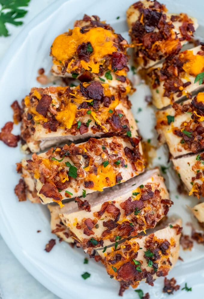 Photo of baked and sliced crack chicken breasts on a white plate.