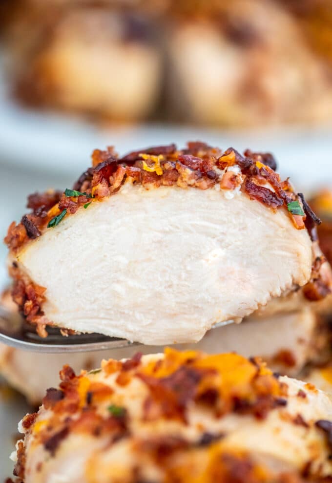 Sliced baked crack chicken garnished with cheese and bacon photo. 