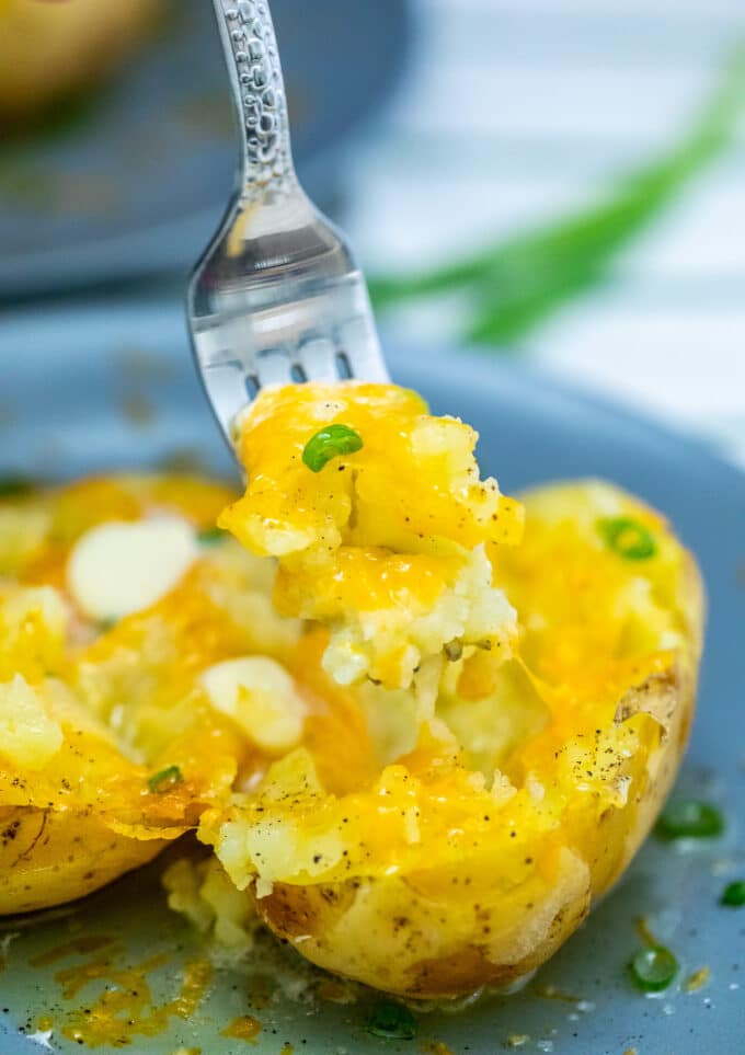 Foto de batata micro-ondas coberta com queijo derretido. 