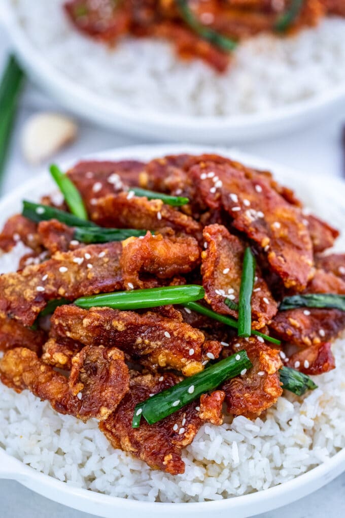 Homemade Mongolian chicken served over a bowl of white rice.