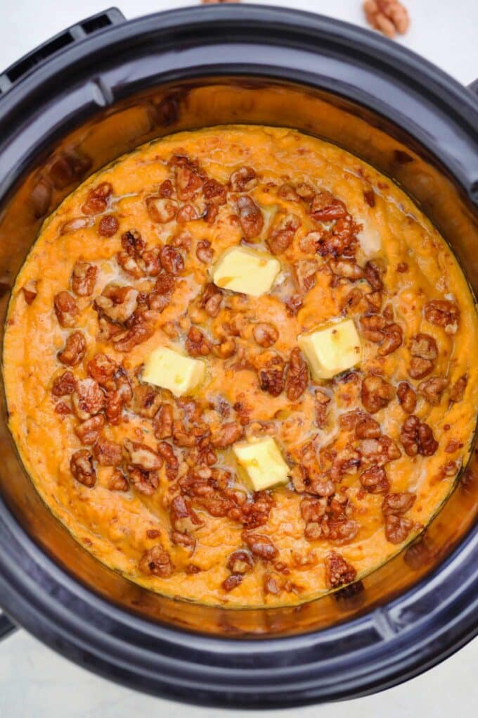Slow cooker mashed sweet potatoes topped with butter and pecans