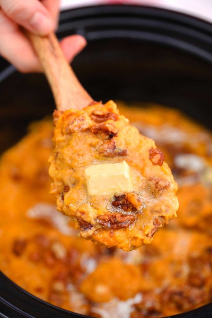 Creamy crockpot mashed sweet potato on a wooden spoon