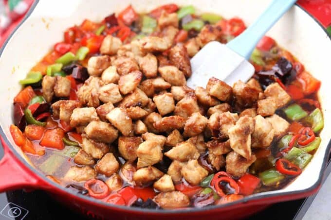 Adding chicken to make Kung Pao Chicken.