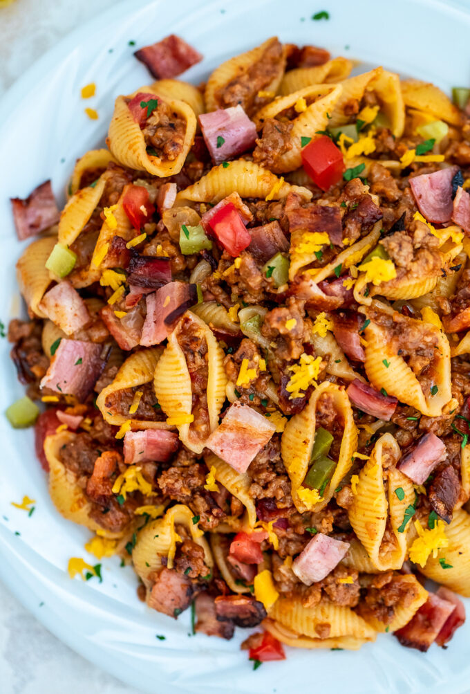 One pan cheeseburger pasta with ground beef, chopped tomatoes, and cheese on a plate