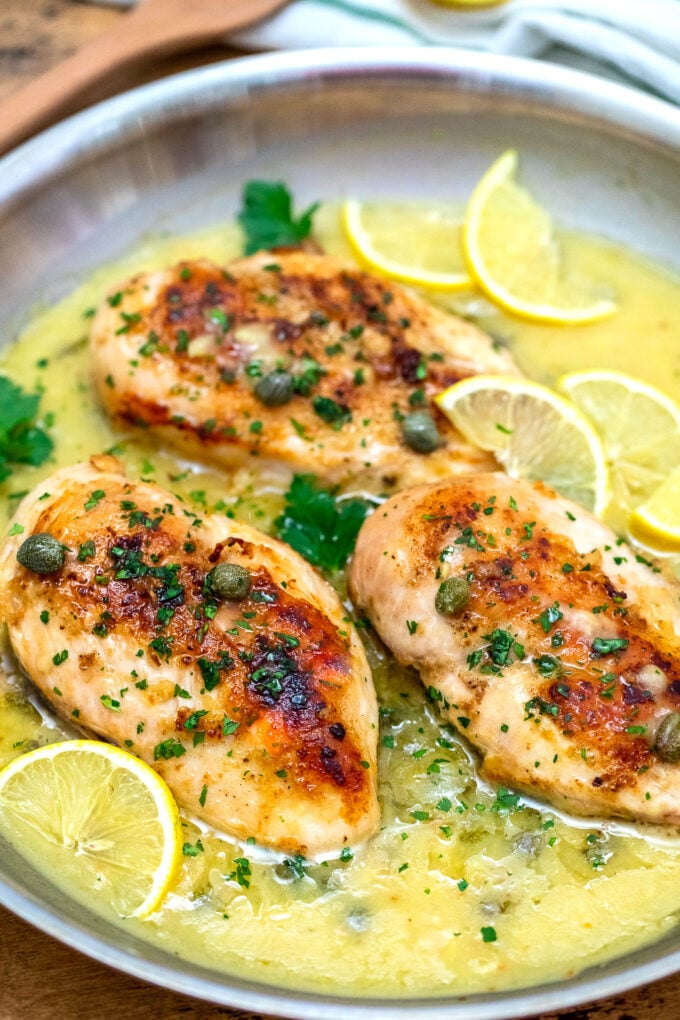 picture of chicken piccata breasts in a creamy lemon garlic sauce in a pan
