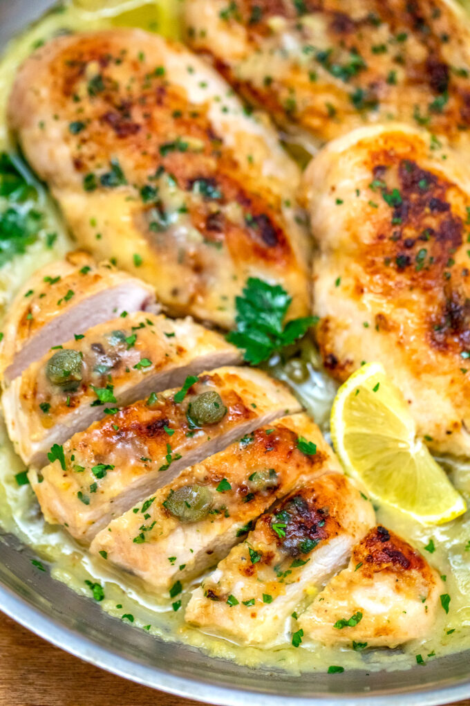 image of sliced chicken piccata breasts garnished with sliced lemon and parsley