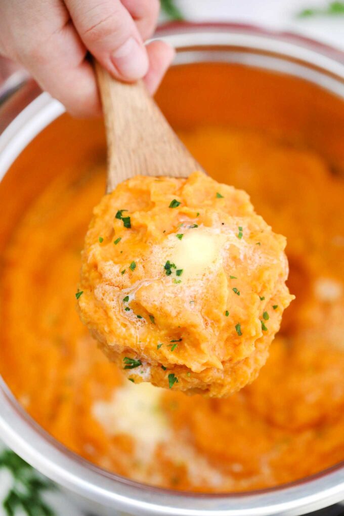 homemade mashed sweet potatoes with butter on a serving spoon