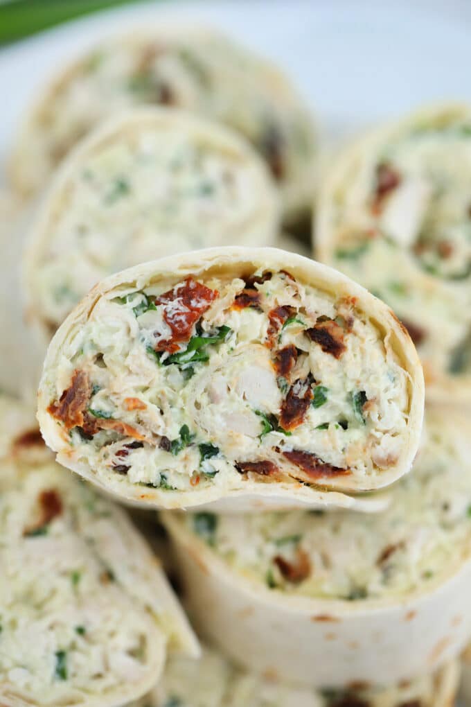 Tuscan Chicken Pinwheels are rolled with a creamy chicken filling! Italian flavors combined in one easy-to-make dish makes this a great lunchbox meal! #chicken #tuscanchicken #pinwheels #sweetandsavorymeals #fingerfood #lunchbox