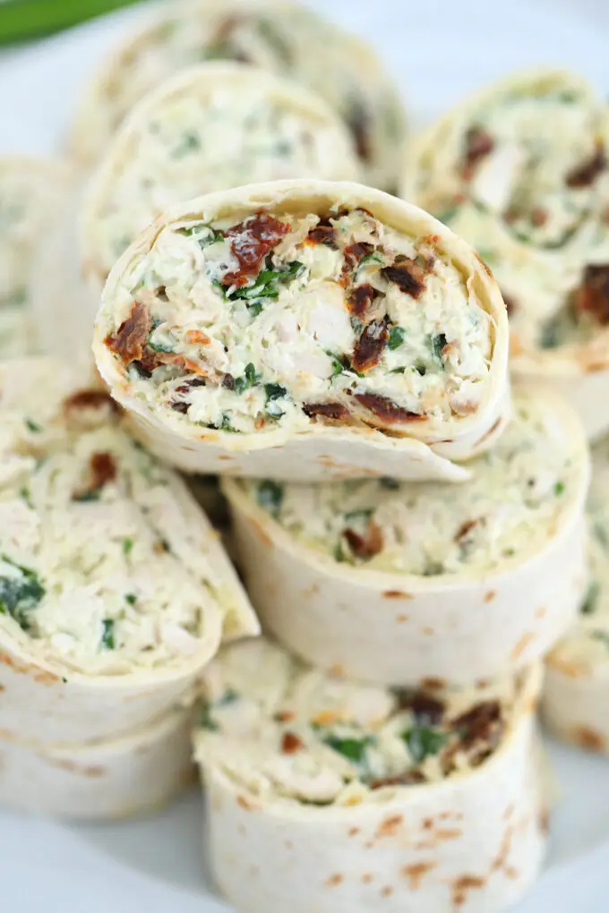 Tuscan Chicken Pinwheels are rolled with a creamy chicken filling! Italian flavors combined in one easy-to-make dish makes this a great lunchbox meal! #chicken #tuscanchicken #pinwheels #sweetandsavorymeals #fingerfood #lunchbox