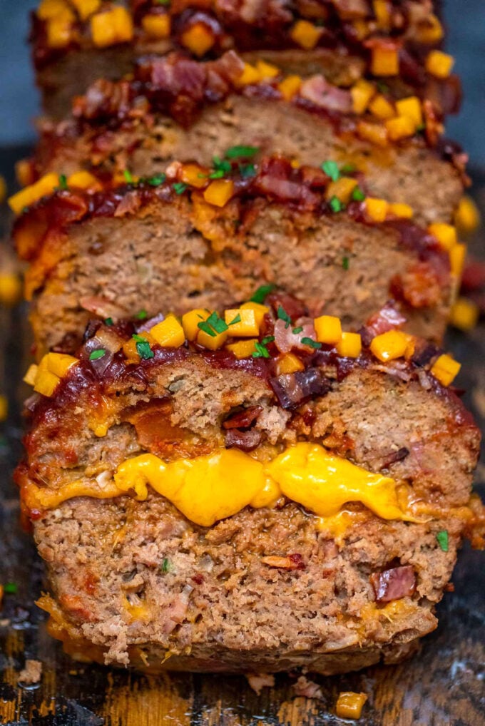 Sliced cheeseburger meatloaf topped with bacon and parsley.