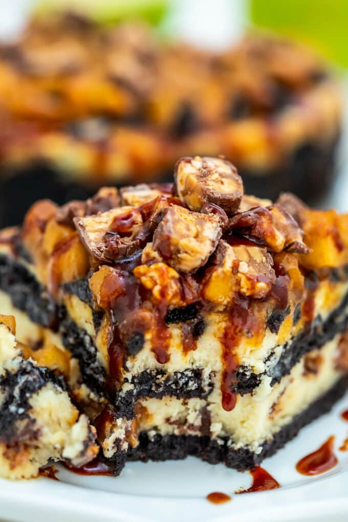 Apple Snickers Cheesecake is not your ordinary dessert! It has your favorite chocolate bar and fruit rolled into one unique and unforgettable cheesecake! #cheesecake #snickers #appledesserts #sweetandsavorymeals #halloweenrecipes