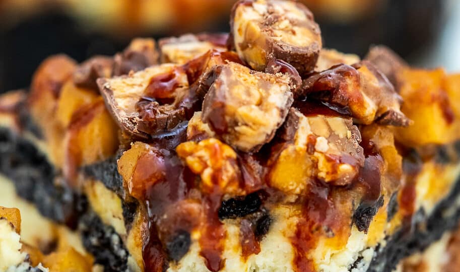 Apple Snickers Cheesecake is not your ordinary dessert! It has your favorite chocolate bar and fruit rolled into one unique and unforgettable cheesecake! #cheesecake #snickers #appledesserts #sweetandsavorymeals #halloweenrecipes