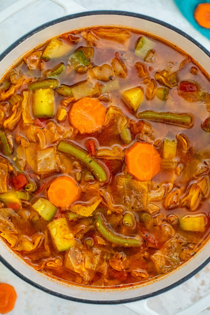 a large pot of cabbage soup with green beans carrots and cabbage