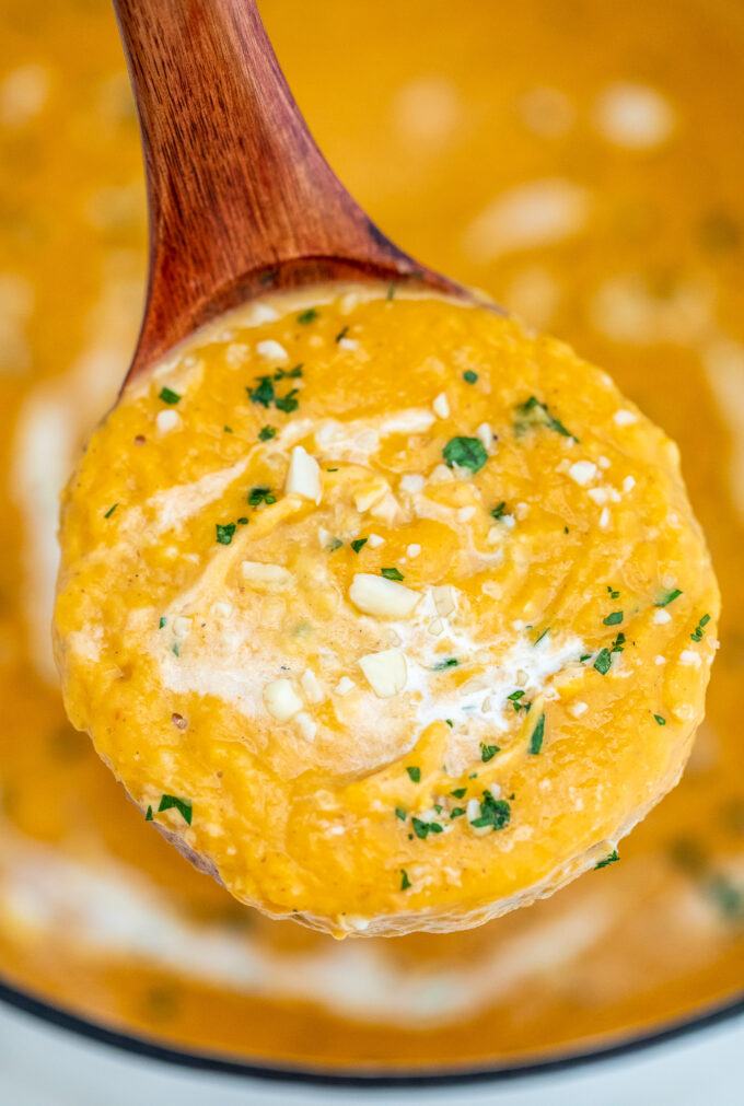 A spoonful of homemade sweet potato soup garnished with chopped parsley