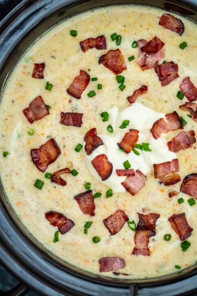 slow cooker ham and potato soup garnished with bacon. 