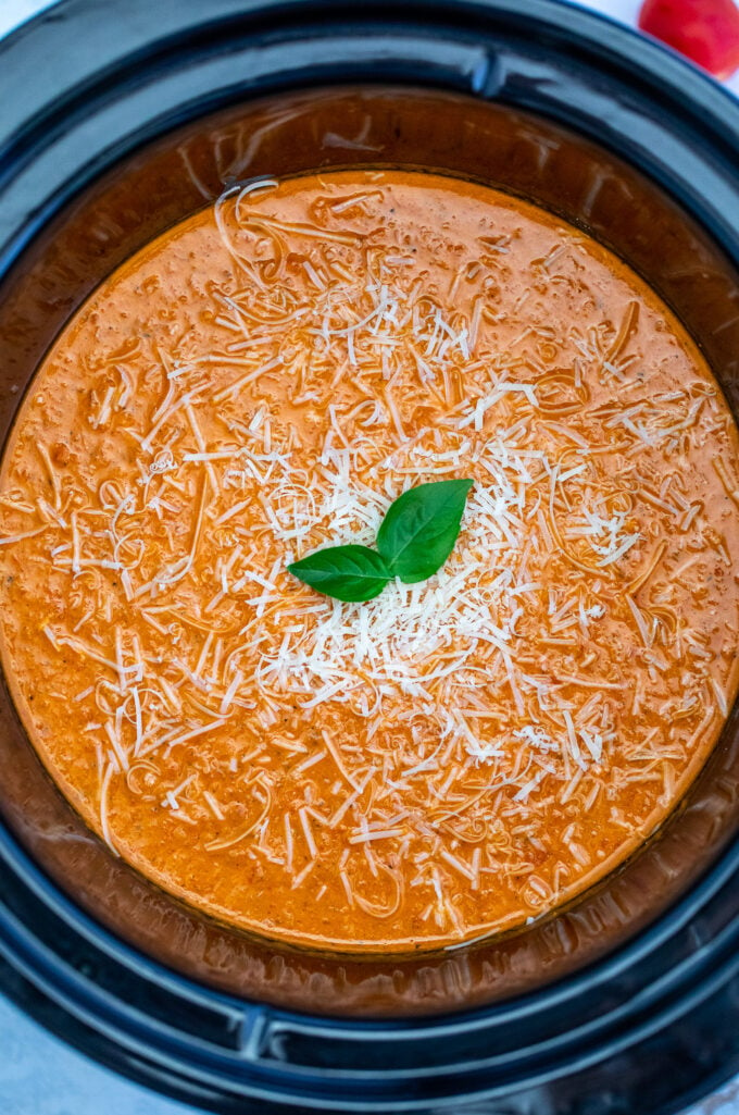 Creamy tomato soup made in the crockpot and topped with shredded cheese and basil leaves