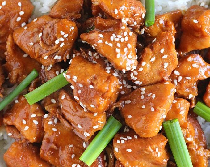 Mongolian chicken with rice and topped with green onions and sesame seeds