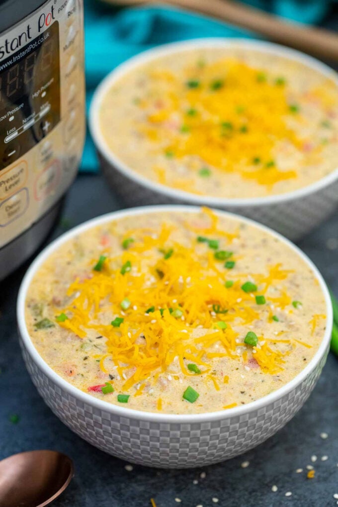 Picture of cheeseburger soup garnished with shredded cheese.