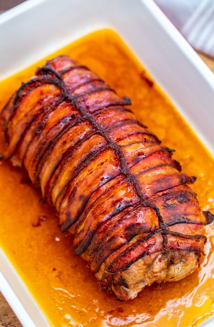 Bacon Wrapped Pork Loin is a sumptuous main dish that is perfect for the holidays! It is festive and full of flavors that your guests will surely love! #bacon #pork #porkloin #sweetandsavorymeals #dinnerideas