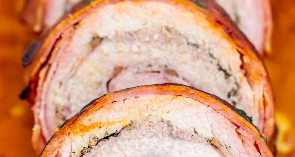 Bacon Wrapped Pork Loin is a sumptuous main dish that is perfect for the holidays! It is festive and full of flavors that your guests will surely love! #bacon #pork #porkloin #sweetandsavorymeals #dinnerideas