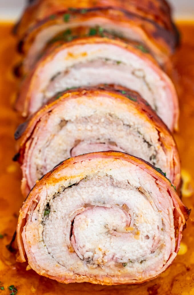 Bacon Wrapped Pork Loin is a sumptuous main dish that is perfect for the holidays! It is festive and full of flavors that your guests will surely love! #bacon #pork #porkloin #sweetandsavorymeals #dinnerideas