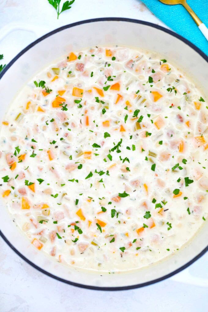 Easy ham and bean soup in a large Dutch oven garnished with chopped parsley