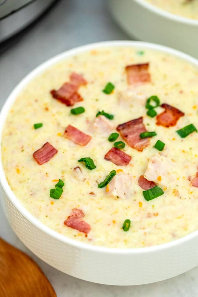 Image of homemade ham and potato soup topped with bacon and green onion.